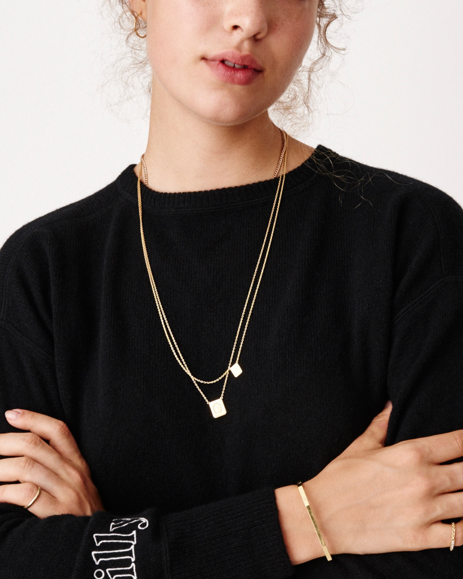 Young girl wearing two personalized gold tag necklaces by love billy and a billy sweatshirt.