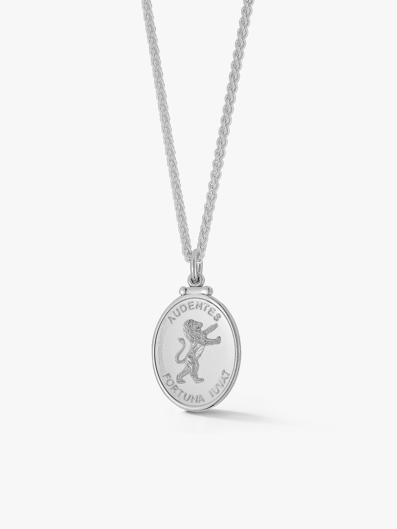 a silver lion medallion. A silver necklace with a round medallion pendant featuring a lion design, on a white background. Engraved with "Audentes fortuna iuvat: fortune favors the bold. In order to win, you have to take chances."
