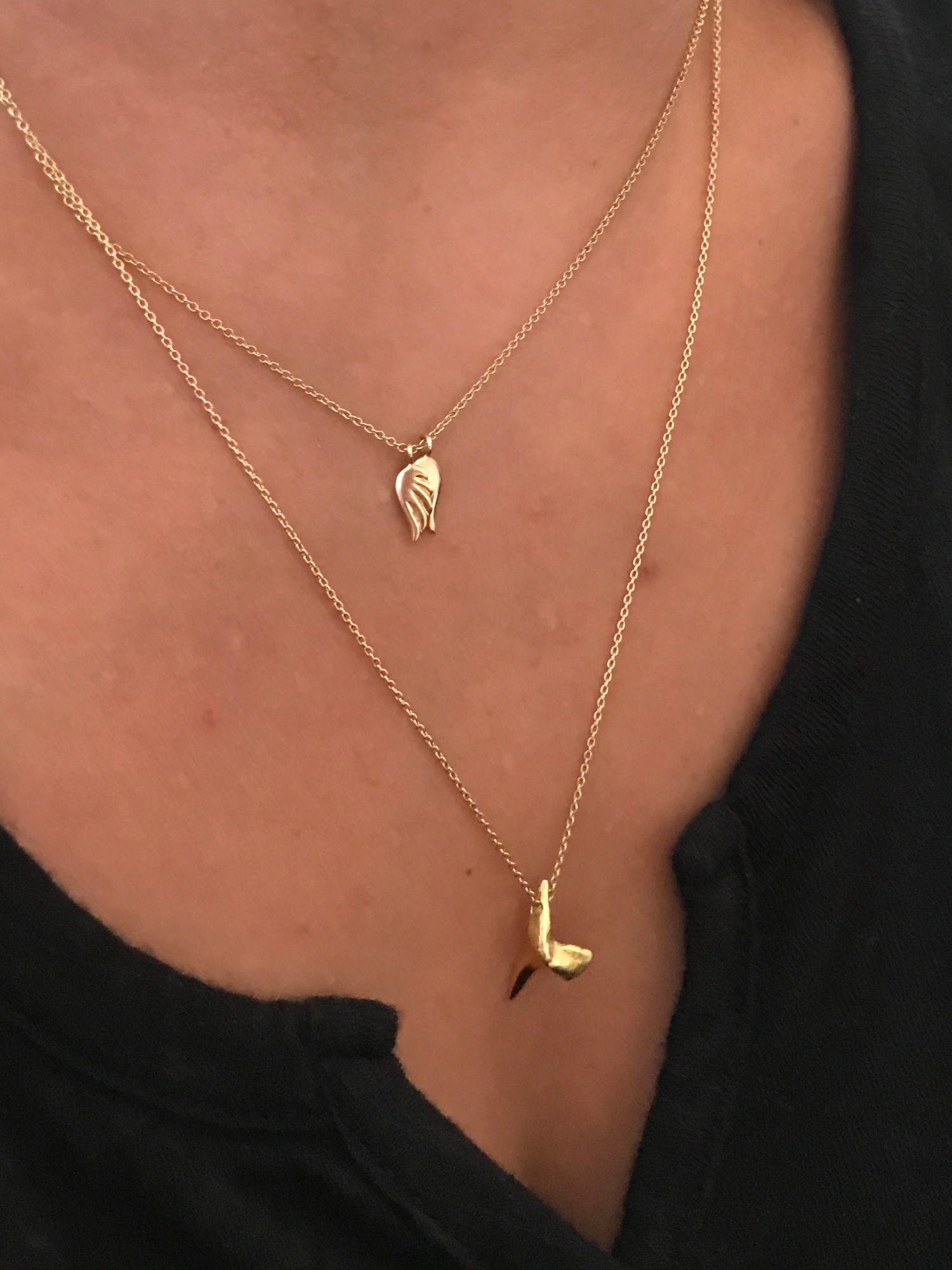 a girl wearing the gold shark tooth necklace by love billy on a cable chain.