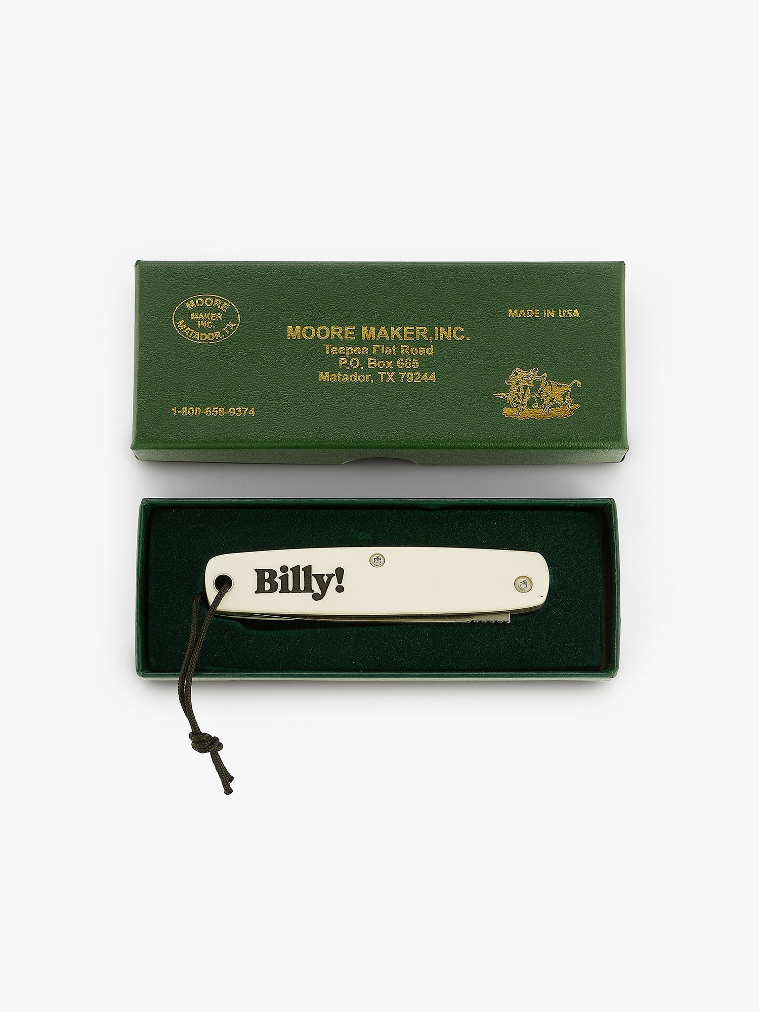 Smal with pocketl knife with black 'Billy!' engraving in a green box. Made in partnership with moore maker, inc in matador, texas. natural bone handle, super sharp blade, and a paracord lanyard hand tied right here in our office. Love Billy.