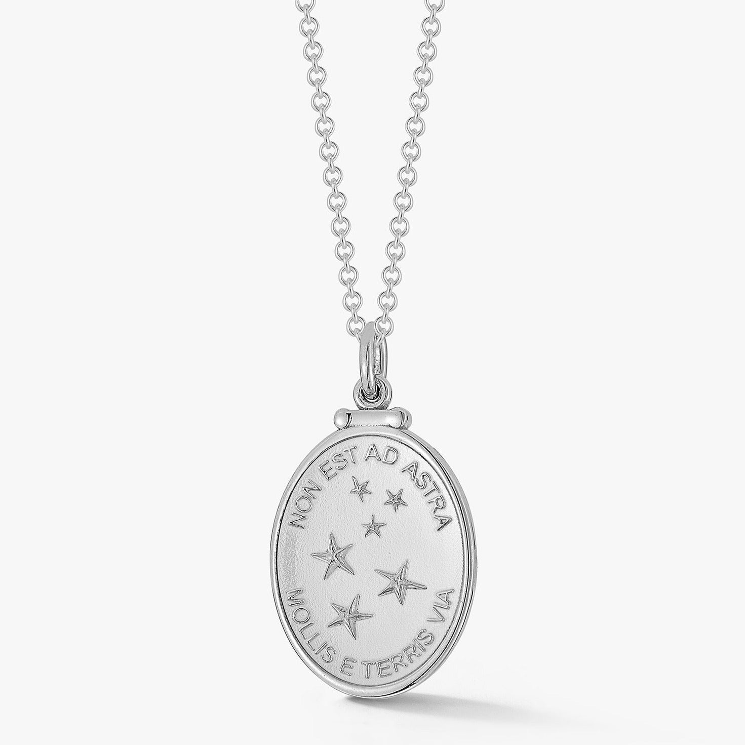 oval silver pendant with pattern of stars and latin phrase meaning the only way to the stars is from the earth by love billy.