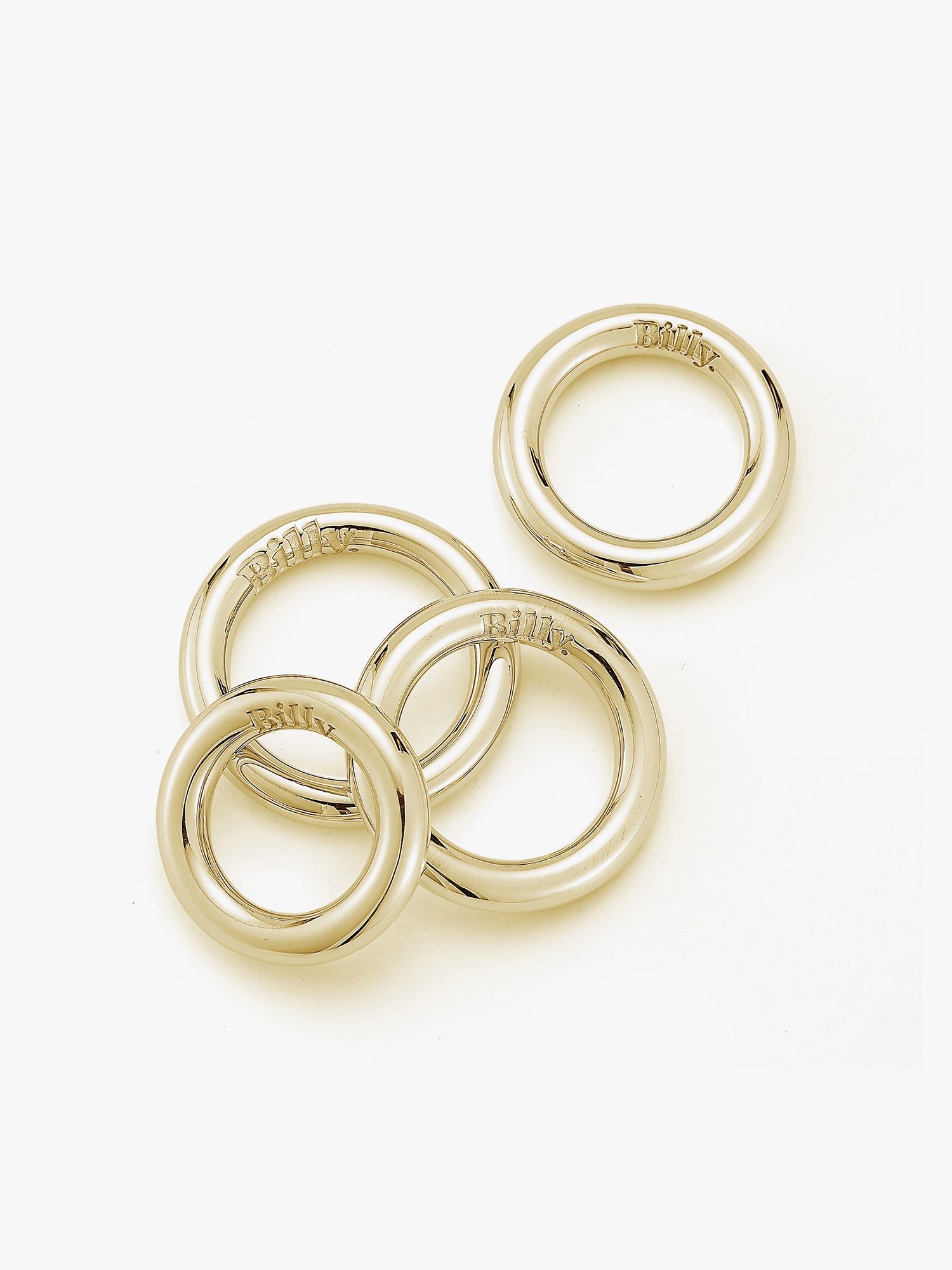 Four gold carousel rings by love billy laid next to each other.