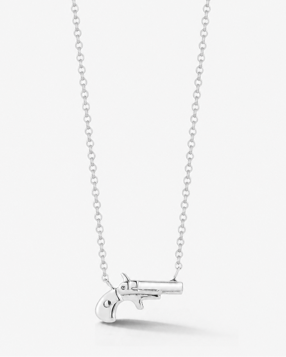 A silver chain necklace featuring a small, polished silver pistol pendant, displayed against a clean, light gray background.