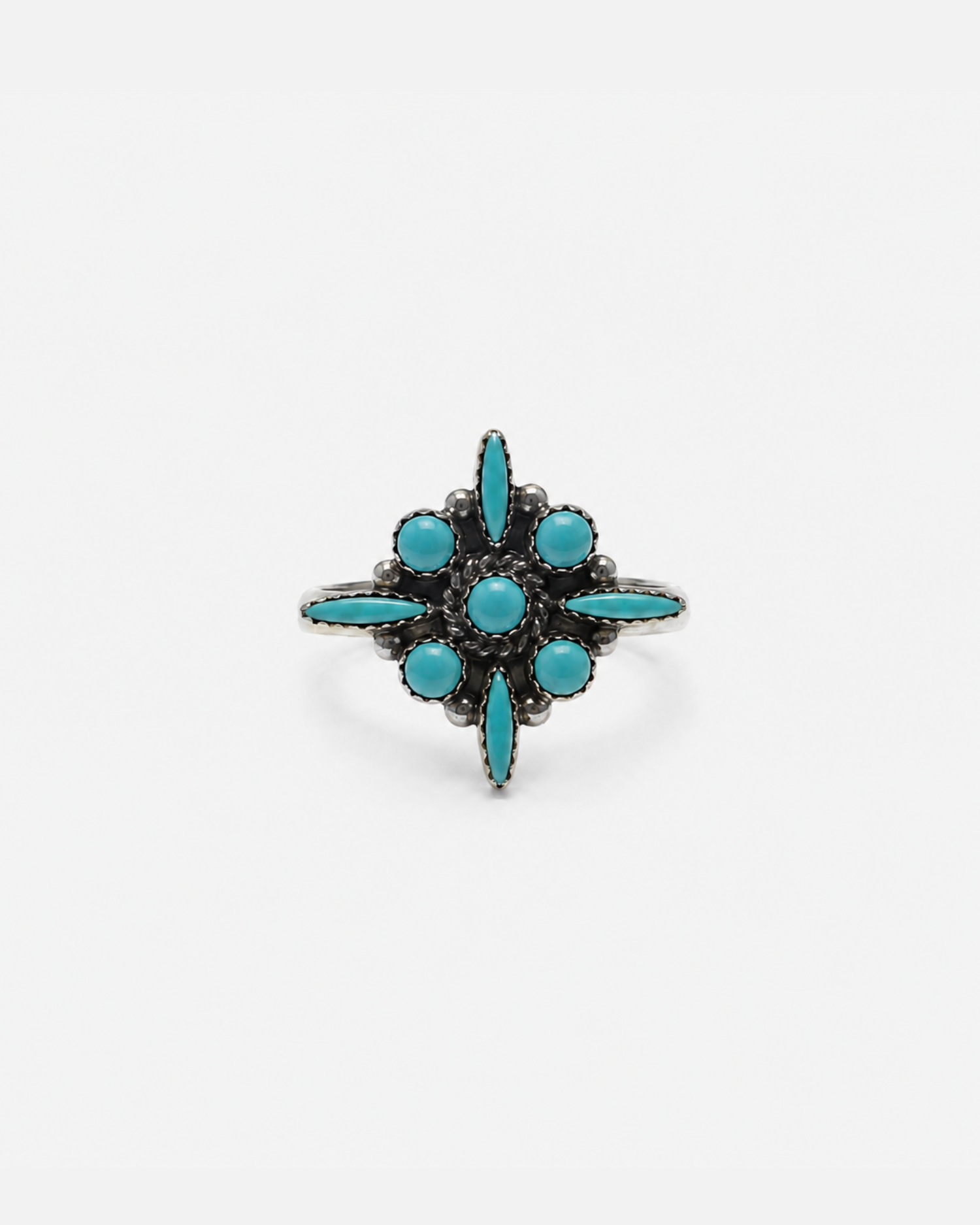 A silver-toned vintage ring featuring a six-pointed starburst design set with turquoise-colored stones, photographed against a plain white background.