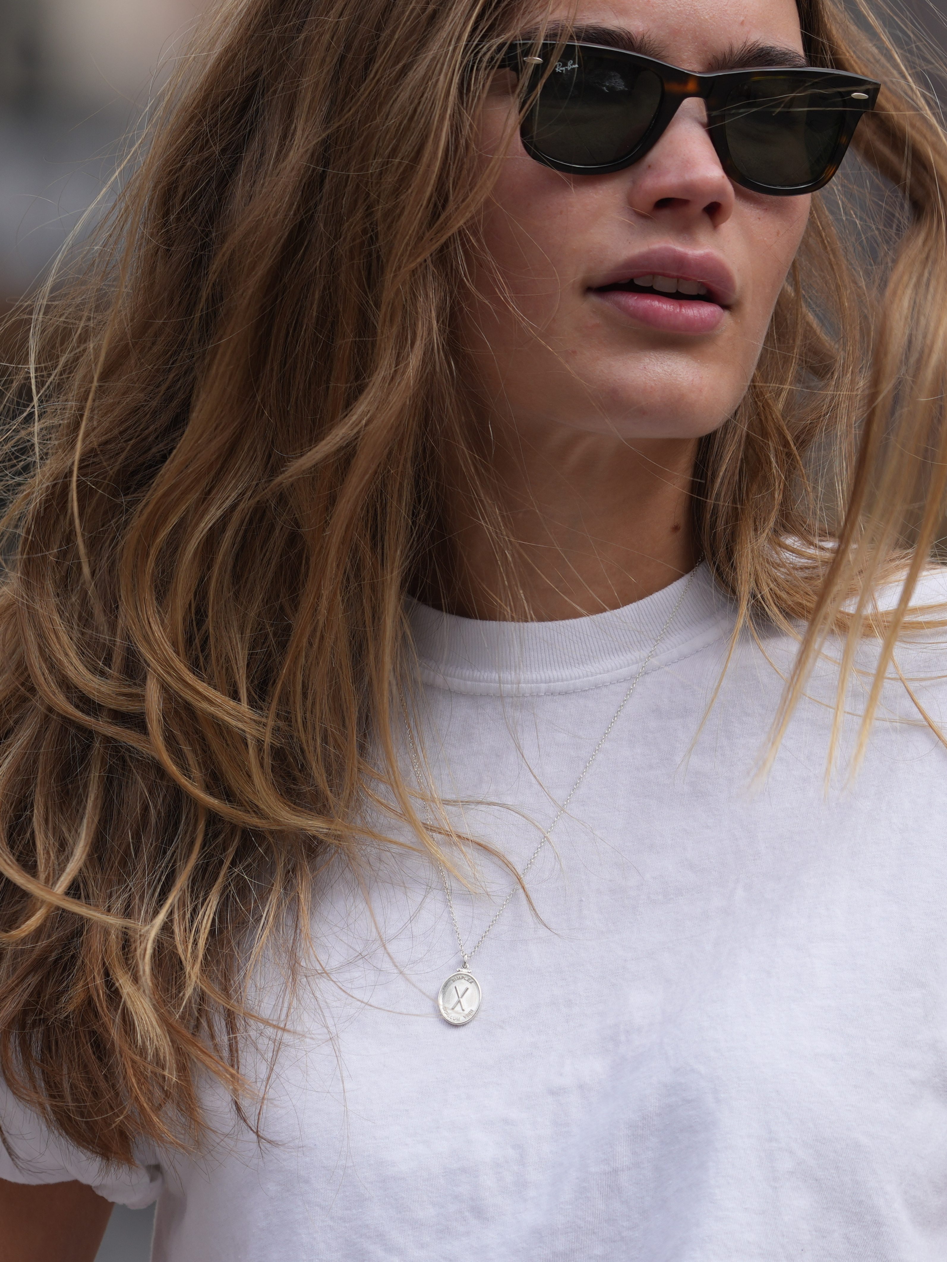 young girl wearing oval silver pendant with an X and latin phrase meaning simplicity is the sign of truth by love billy.