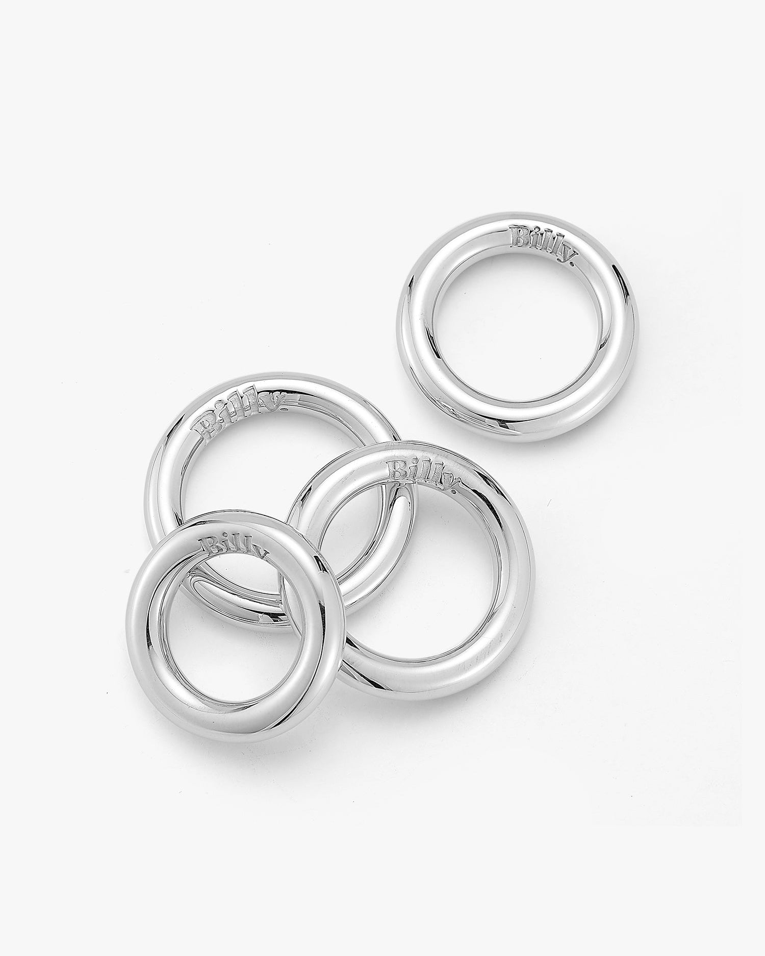 Four silver carousel rings by love billy laid next to each other.