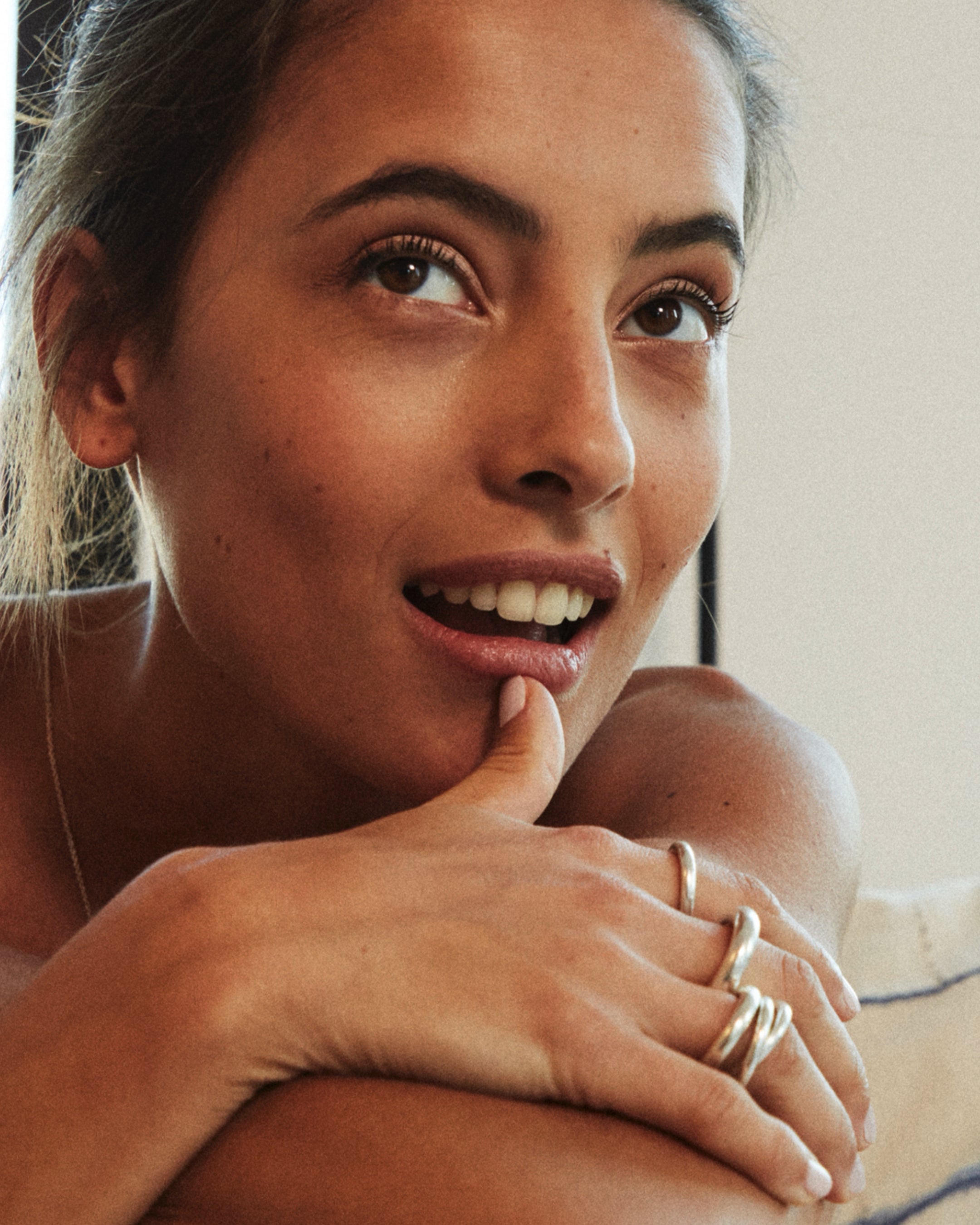 Woman with rings on her finger, close-up of face and hand