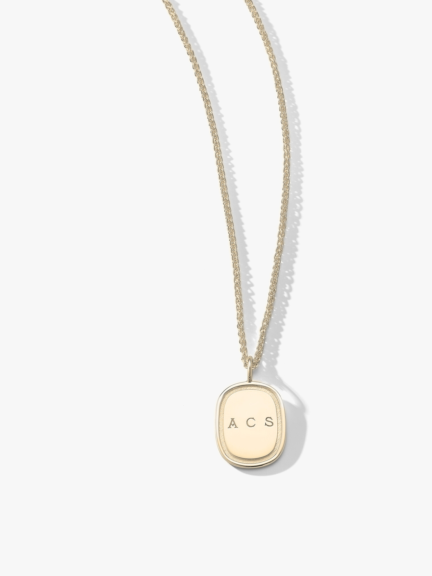Gold oblong pendant engraved with "ACS" on a 14k chain. Made by Love Billy in NYC.