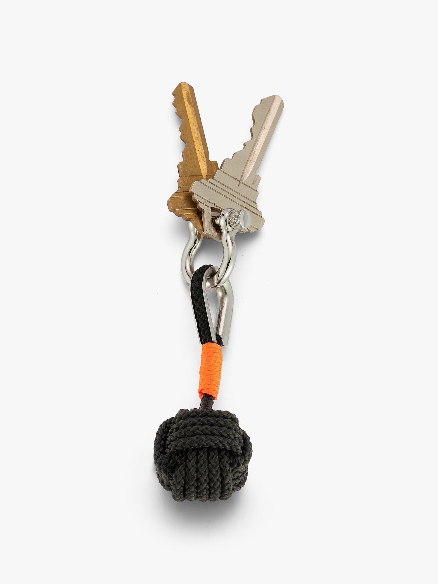 Overhead view of monkey fist charm keychain attacked to two keys. Ball knot shape with a shackle closure and orange accent. Love Billy NYC.