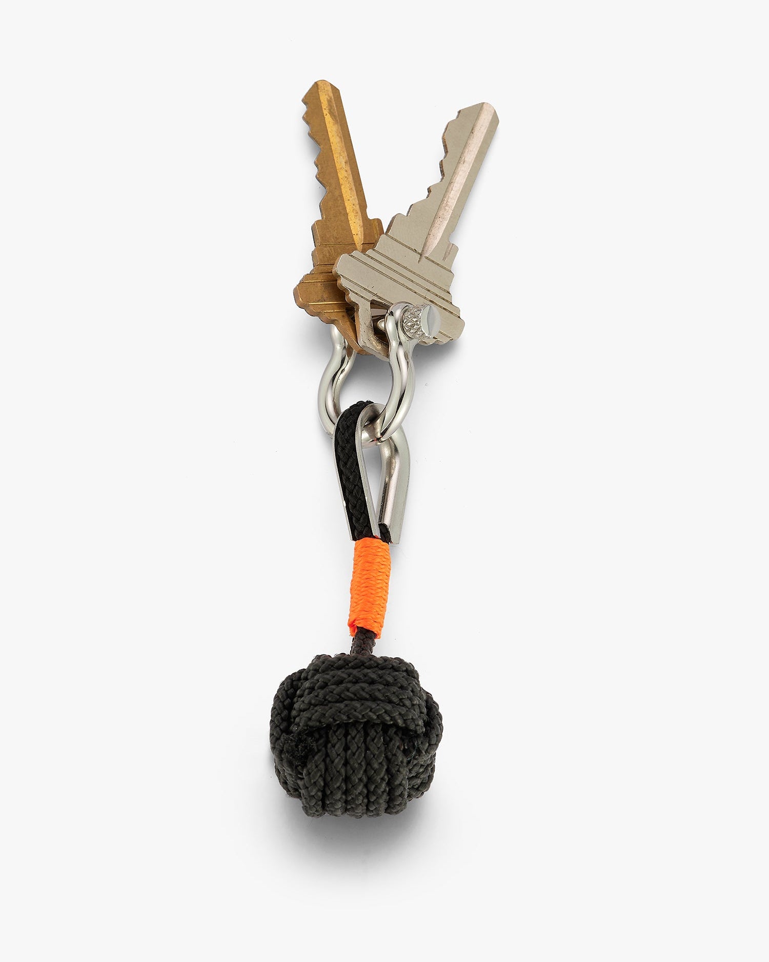 Overhead view of monkey fist charm keychain attacked to two keys. Ball knot shape with a shackle closure and orange accent. Love Billy NYC.