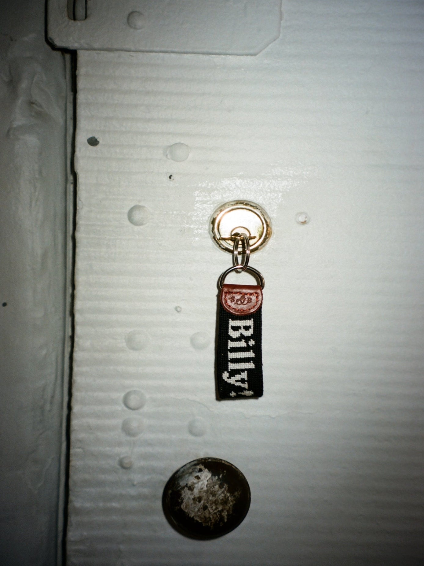 needleopoint keychain with 'BILLY!' branding