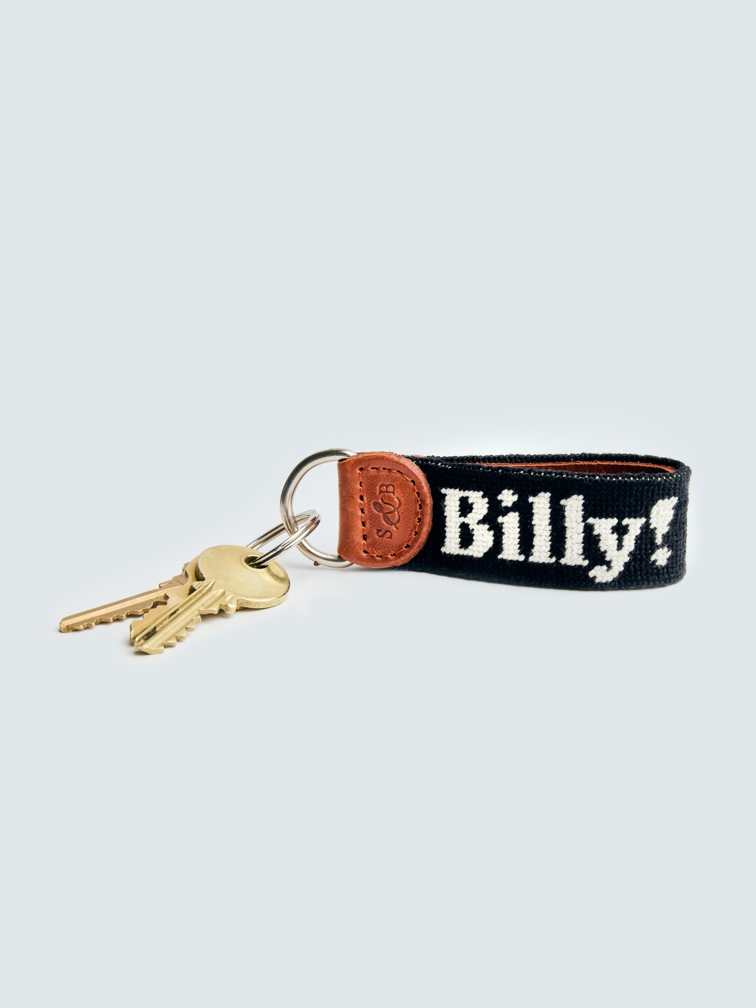 Love billy keychain with two gold keys attached.