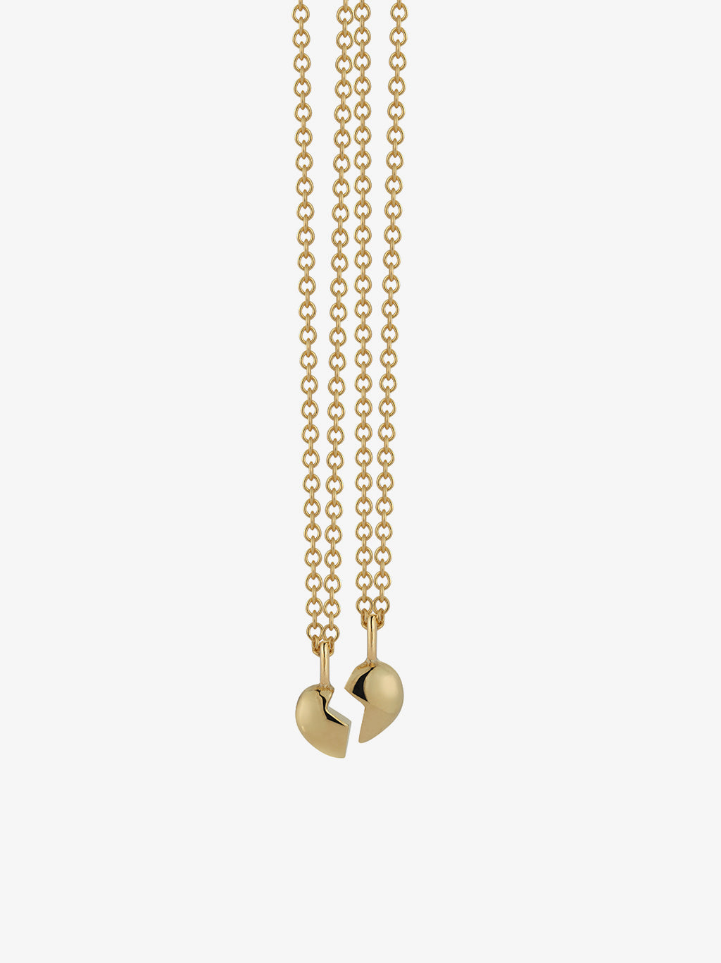 two halves of the gold split heart necklace by love billy next to each other.