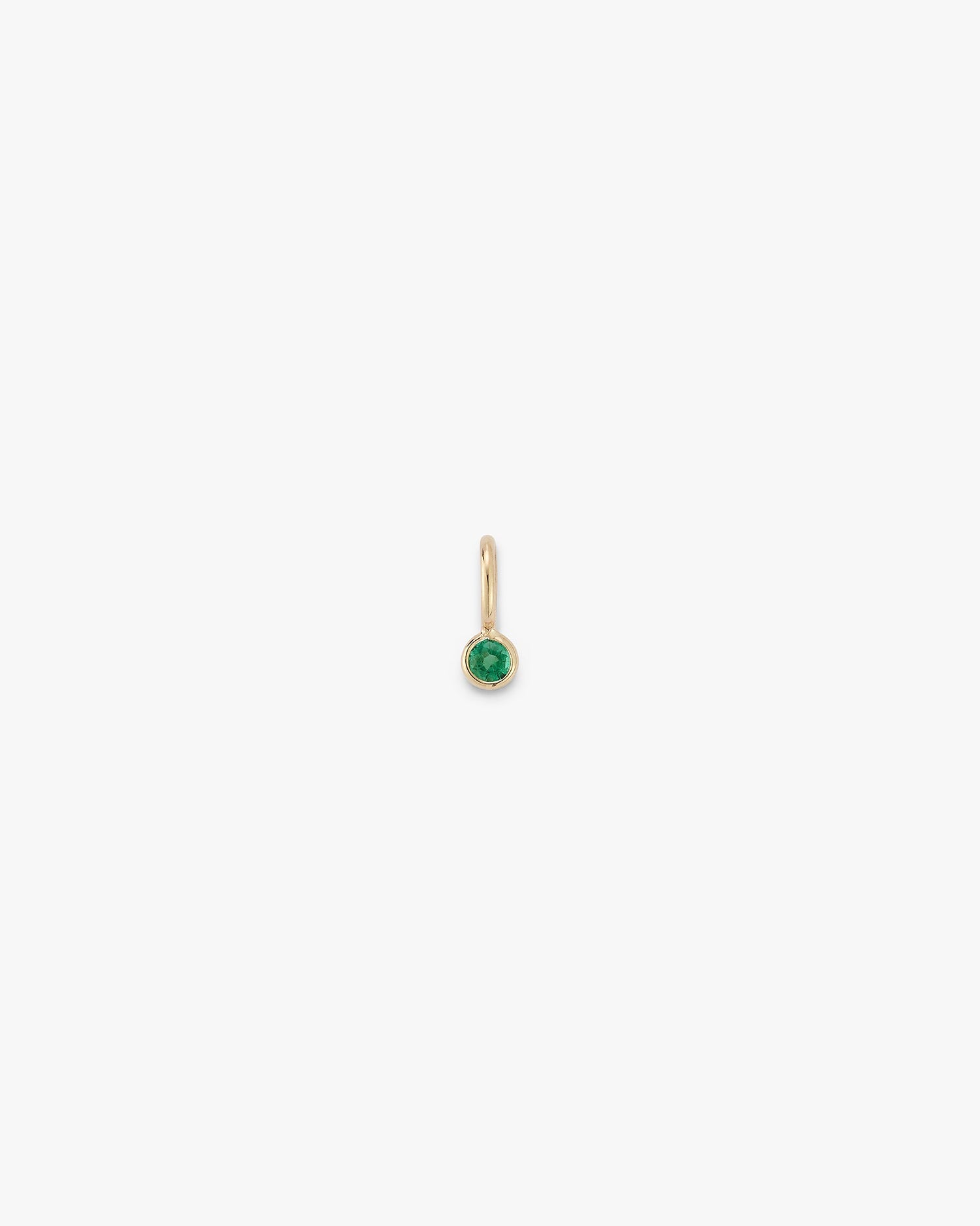 Gold gemstone drop with an emerald on a green background 