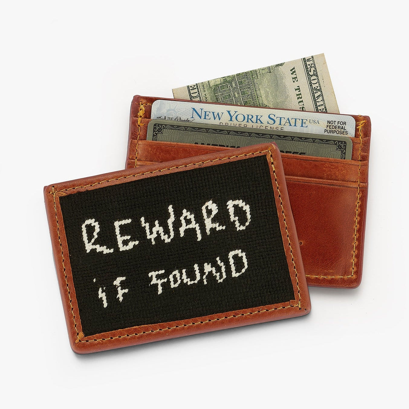 Small leather wallet with a black patch displaying 'REWARD IF FOUND' on a white background.