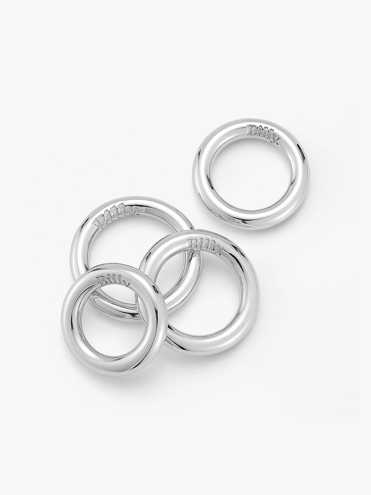 Four silver carousel rings by love billy laid next to each other.
