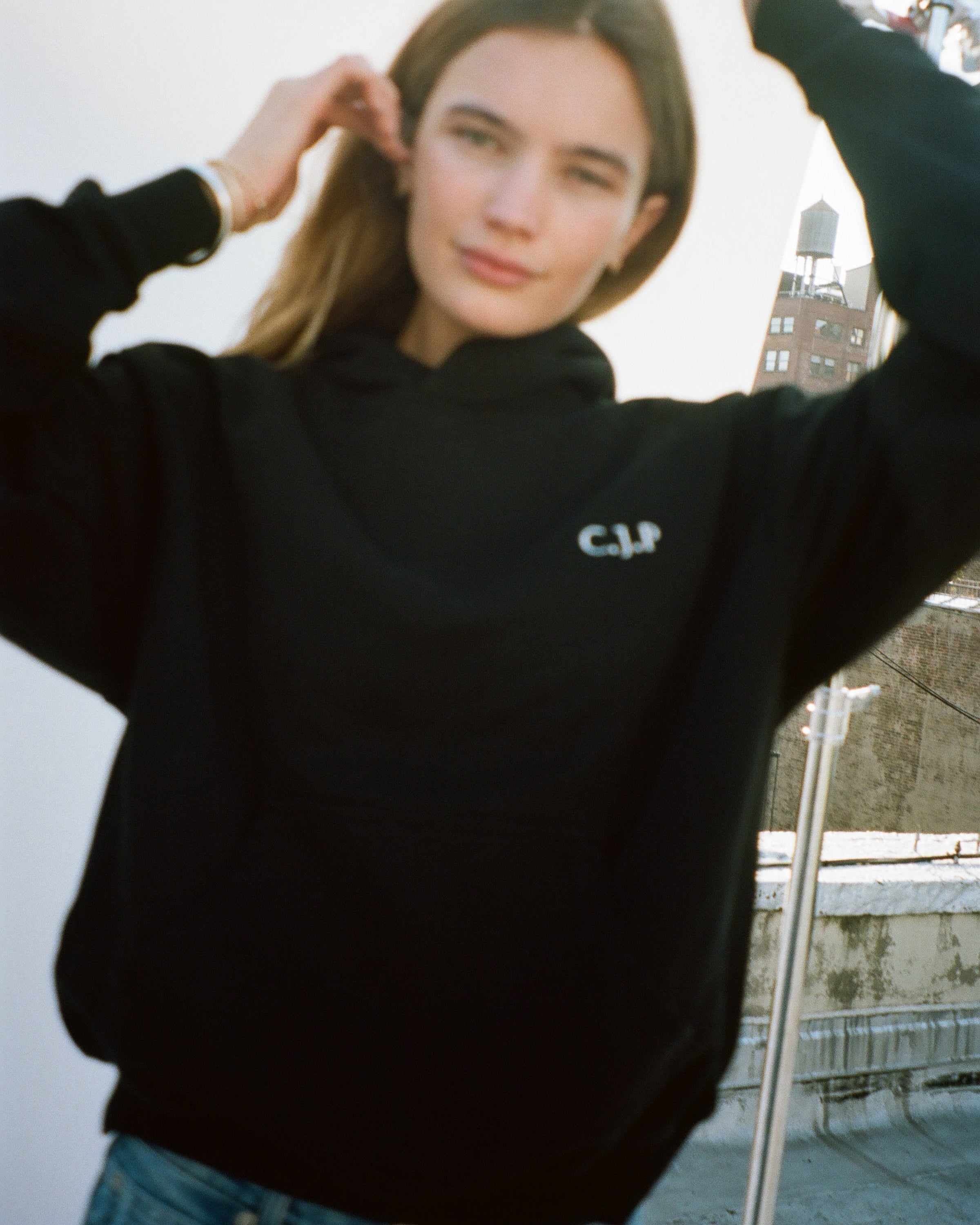 girl wearing the love billy black hoodie with her initials monogrammed on the front.