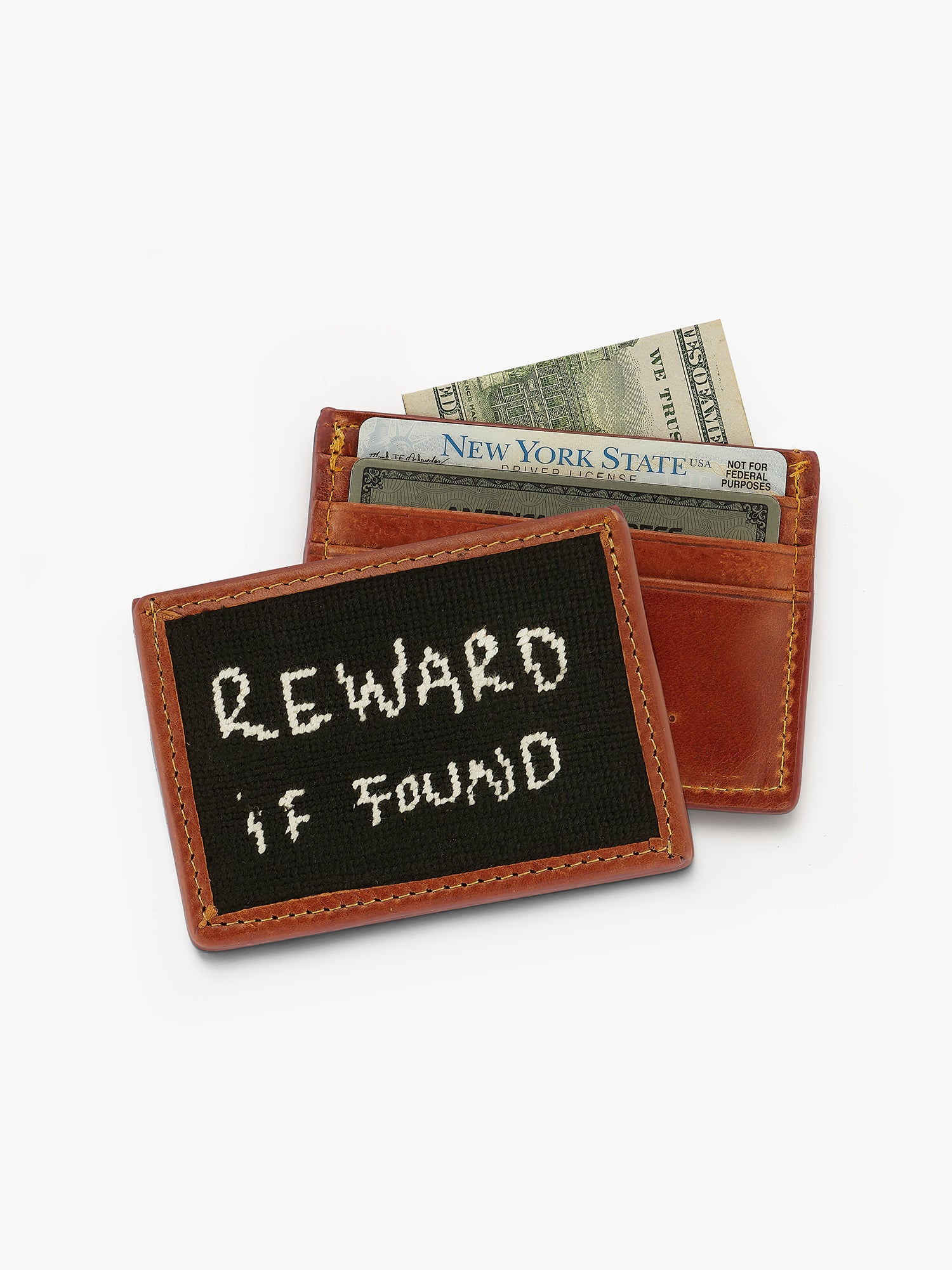 Small leather smanthers and Branson wallet with a black patch displaying 'REWARD IF FOUND' on a white background. Made in collaboration with love Billy NYC 