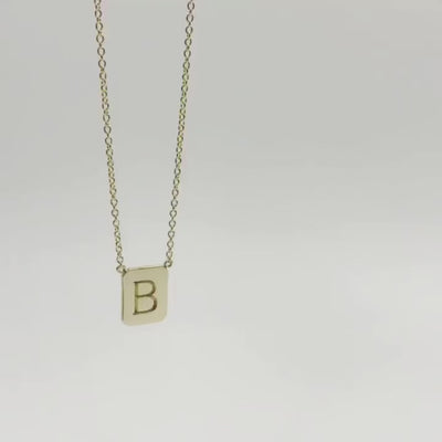 movie of gold tag necklace dropping though the screen