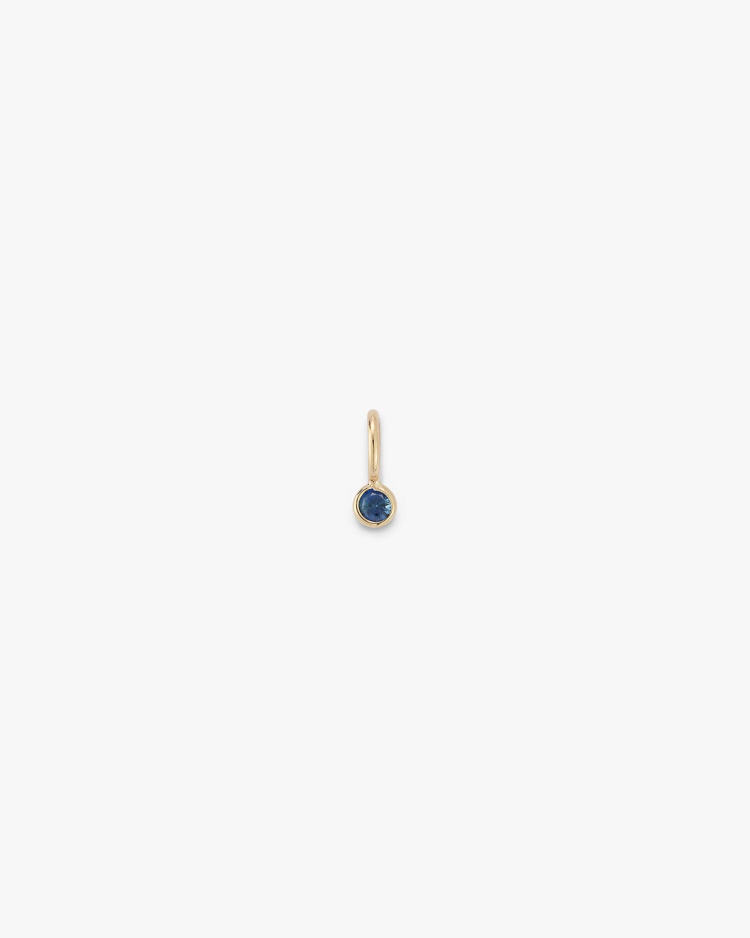 Gold gemstone drop with a sapphire on a white background 