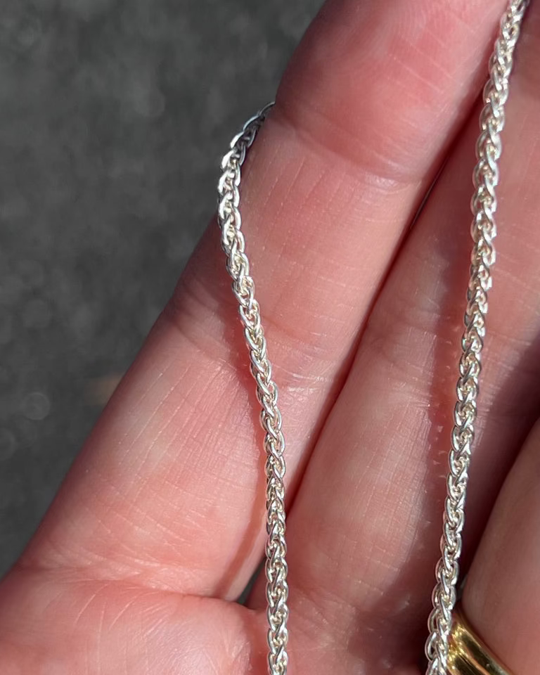 love billy silver wheat chain being held.